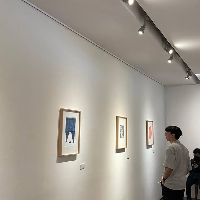 Looking at framed prints in a small gallery